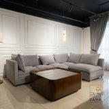 Grey L-shape sectional sofa with wooden coffee table by Zama Home Store in a modern room
